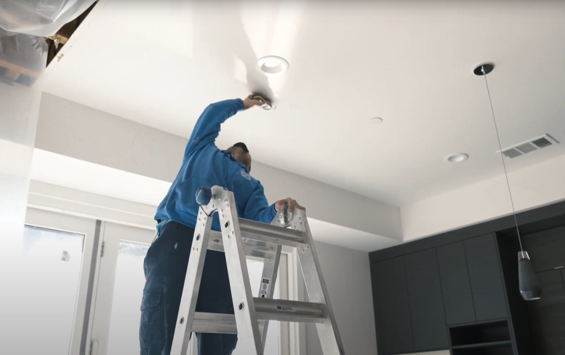 Professional water damage restoration technician working on ceiling repairs